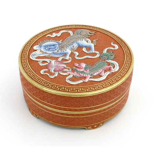 47 - A Chinese box of circular form with foo dog / guardian lion detail, with gilt border. Character mark... 