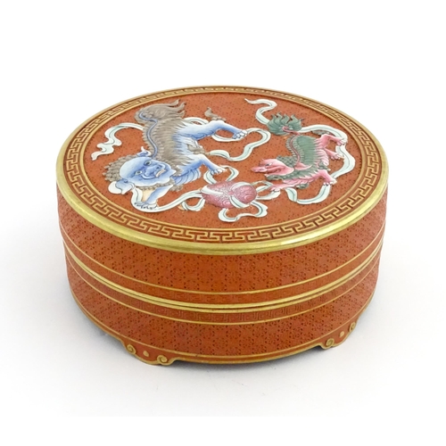 47 - A Chinese box of circular form with foo dog / guardian lion detail, with gilt border. Character mark... 