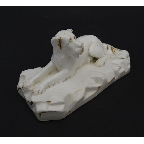 58 - A 19thC porcelain model of a recumbent Great Dane dog on a rocky base, with gilt highlights. Possibl... 