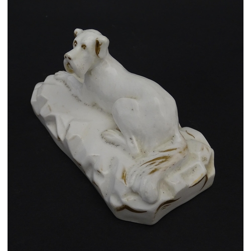 58 - A 19thC porcelain model of a recumbent Great Dane dog on a rocky base, with gilt highlights. Possibl... 