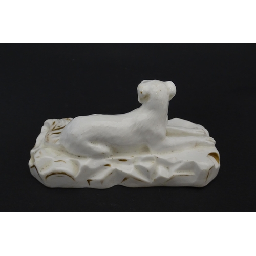 58 - A 19thC porcelain model of a recumbent Great Dane dog on a rocky base, with gilt highlights. Possibl... 