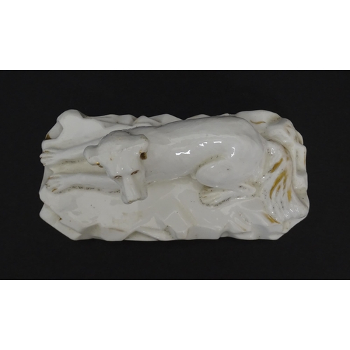 58 - A 19thC porcelain model of a recumbent Great Dane dog on a rocky base, with gilt highlights. Possibl... 