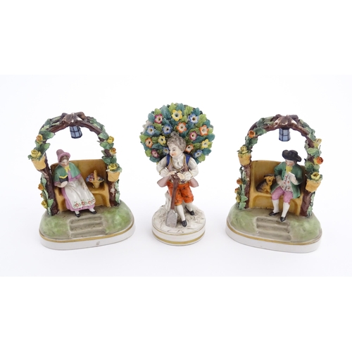 62 - A pair of porcelain figures models of a seated man and woman reading under a flower arch with lanter... 