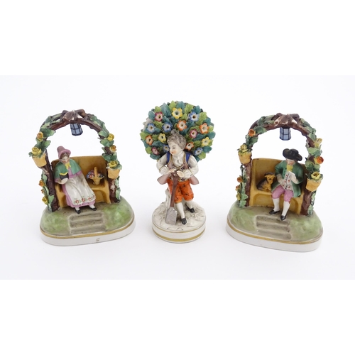 62 - A pair of porcelain figures models of a seated man and woman reading under a flower arch with lanter... 