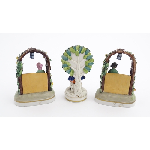 62 - A pair of porcelain figures models of a seated man and woman reading under a flower arch with lanter... 