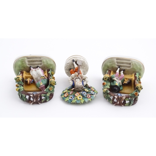 62 - A pair of porcelain figures models of a seated man and woman reading under a flower arch with lanter... 