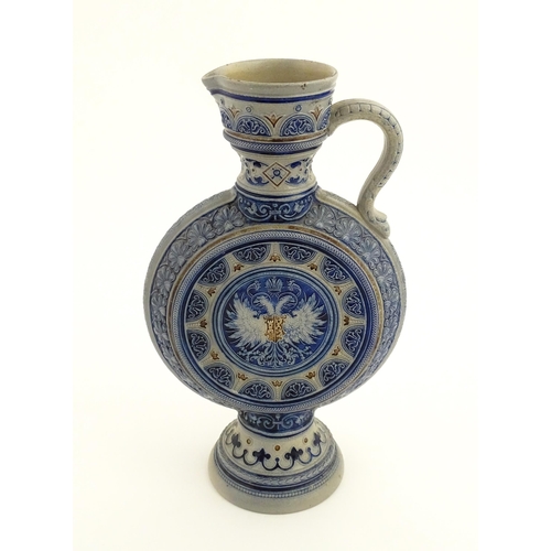 75 - A German Westerwald salt glazed ewer / flask with double headed eagle detail. Impressed under 566A. ... 