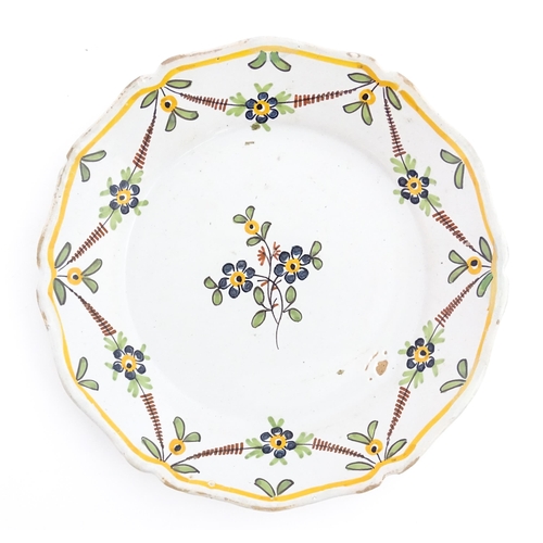 77 - Two Continental faience plates of shaped form with hand painted flower decoration. Approx. 9