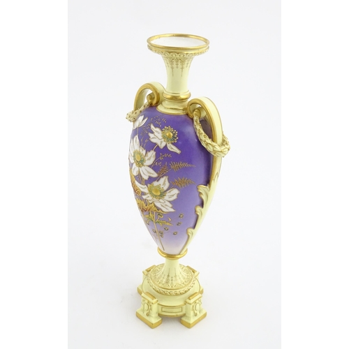 87 - A Royal Worcester cream and purple vase of pedestal baluster form with twin gilt acanthus leaf handl... 