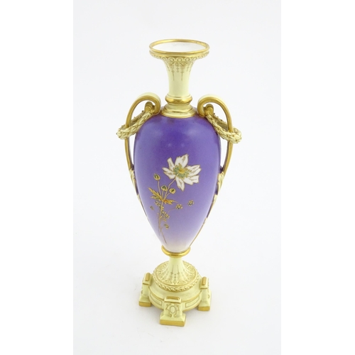 87 - A Royal Worcester cream and purple vase of pedestal baluster form with twin gilt acanthus leaf handl... 