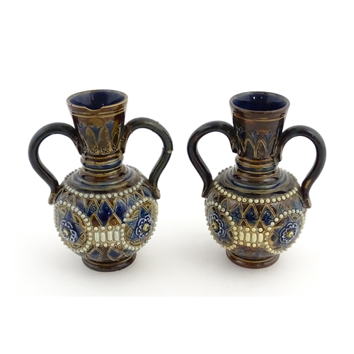 99 - A pair of Doulton Lambeth twin handled vases with roundel detail. Marked under and numbered 448. App... 