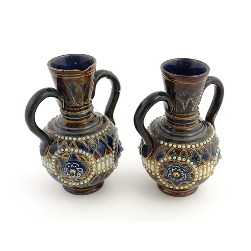 99 - A pair of Doulton Lambeth twin handled vases with roundel detail. Marked under and numbered 448. App... 