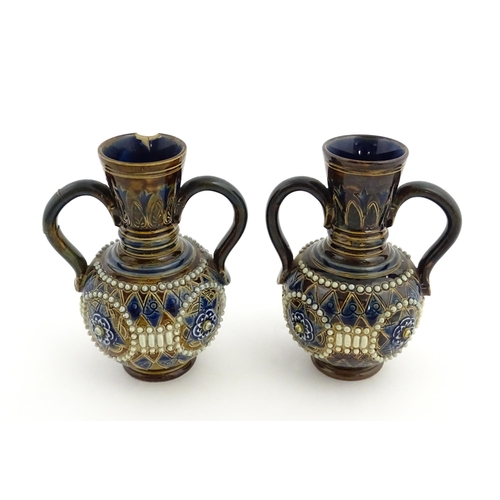 99 - A pair of Doulton Lambeth twin handled vases with roundel detail. Marked under and numbered 448. App... 