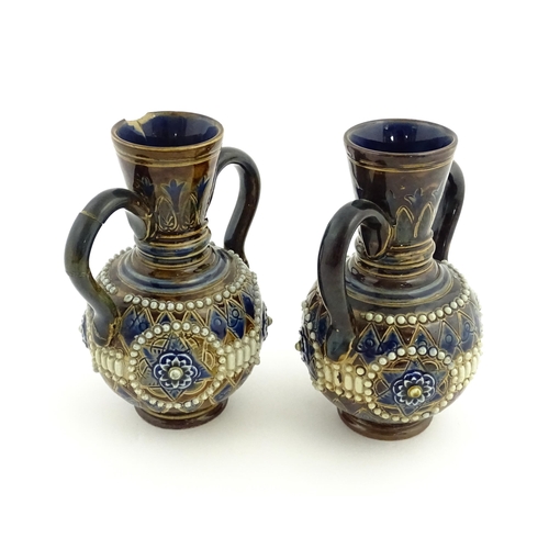 99 - A pair of Doulton Lambeth twin handled vases with roundel detail. Marked under and numbered 448. App... 