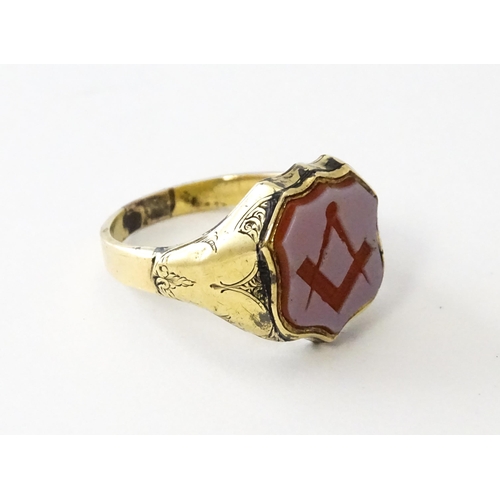 724 - Masonic / Freemasonry Interest: A yellow metal signet ring set with Masonic seal. Ring size approx. ... 