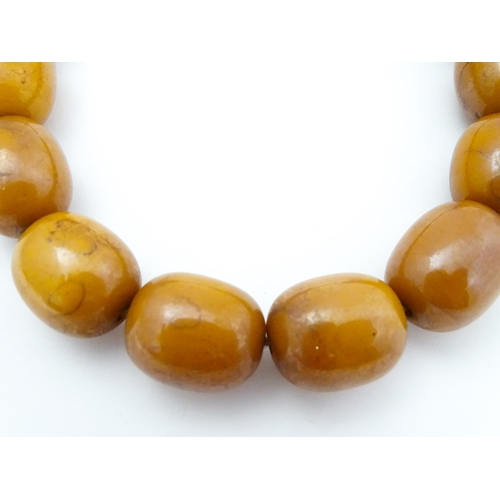 779 - A vintage necklace of amber coloured beads. Largest bead approx. 1