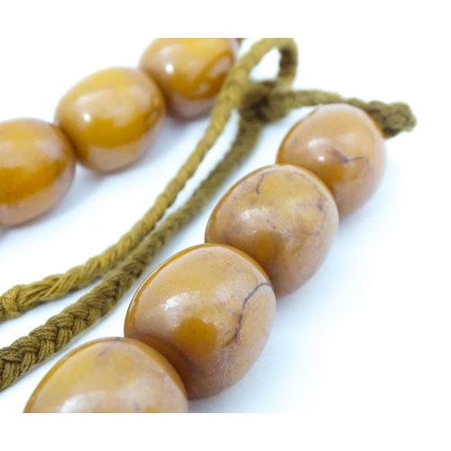 779 - A vintage necklace of amber coloured beads. Largest bead approx. 1