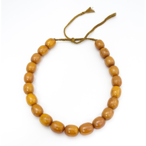 779 - A vintage necklace of amber coloured beads. Largest bead approx. 1