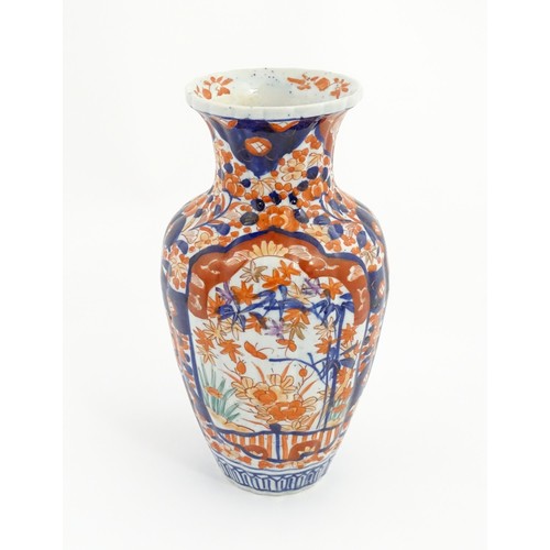 203 - A Japanese vase decorated in the Imari palette with flowers and foliage, with further floral motifs ... 