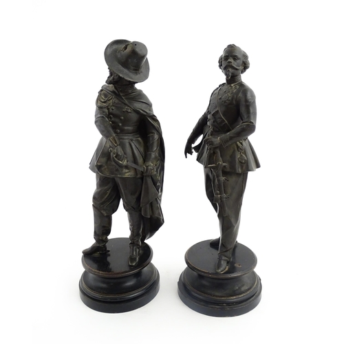 1023 - A pair of 20thC Continental cast military figures in uniform with swords, raised on turned wooden so... 