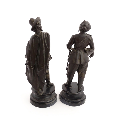 1023 - A pair of 20thC Continental cast military figures in uniform with swords, raised on turned wooden so... 