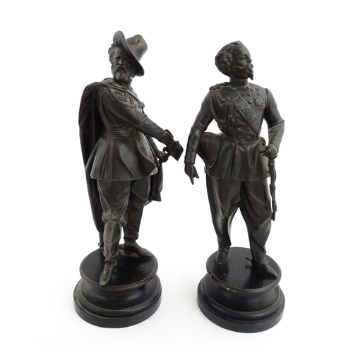 1023 - A pair of 20thC Continental cast military figures in uniform with swords, raised on turned wooden so... 