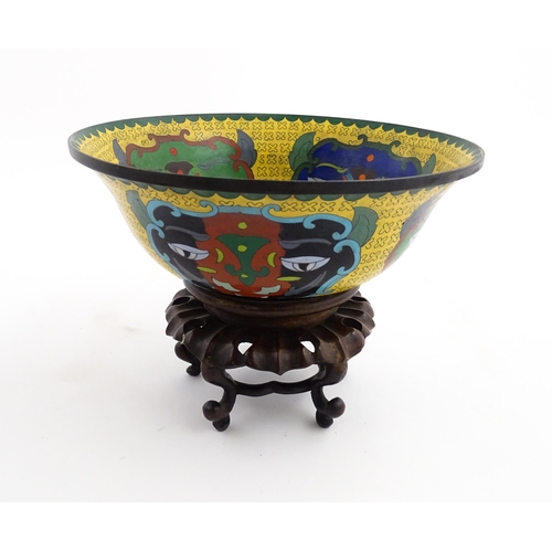 1029 - A Chinese cloisonne bowl of flared form, the yellow ground with stylised mask detail, the interior w... 