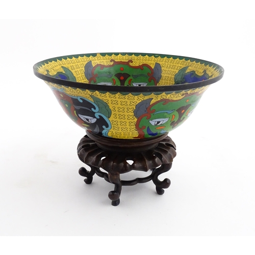 1029 - A Chinese cloisonne bowl of flared form, the yellow ground with stylised mask detail, the interior w... 