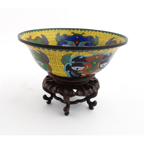 1029 - A Chinese cloisonne bowl of flared form, the yellow ground with stylised mask detail, the interior w... 