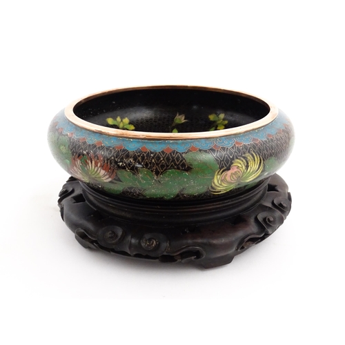 1039 - A Chinese cloisonne bowl, the black ground with floral and foliate decoration. Character marks under... 