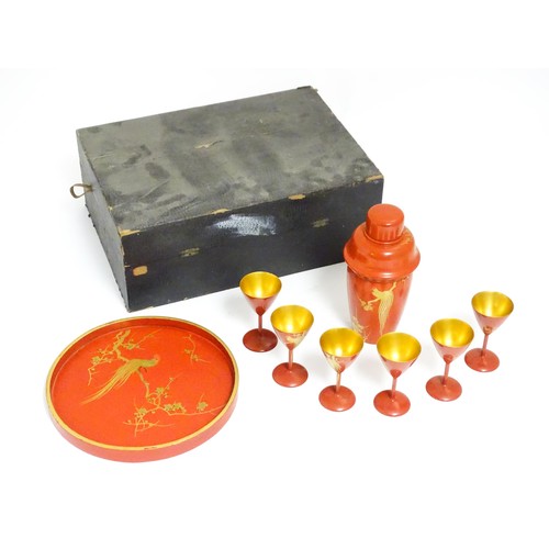 1044 - An Oriental Art Deco style red lacquer cocktail set, comprising six cocktail glasses, a cocktail sha... 