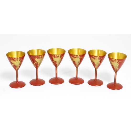 1044 - An Oriental Art Deco style red lacquer cocktail set, comprising six cocktail glasses, a cocktail sha... 