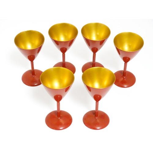 1044 - An Oriental Art Deco style red lacquer cocktail set, comprising six cocktail glasses, a cocktail sha... 