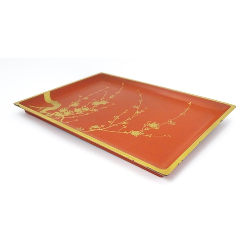 1045 - An Oriental Art Deco style red lacquer cocktail tray of rectangular form decorated with gilt blossom... 