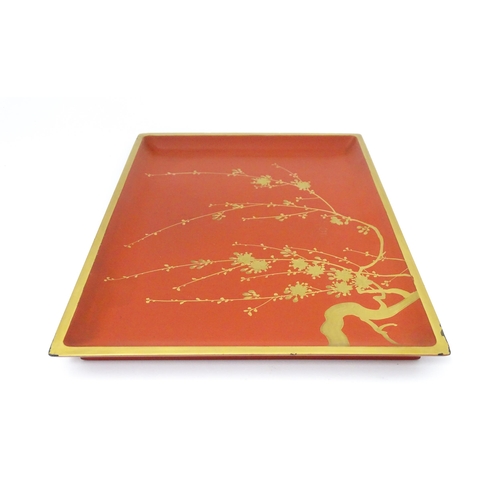 1045 - An Oriental Art Deco style red lacquer cocktail tray of rectangular form decorated with gilt blossom... 