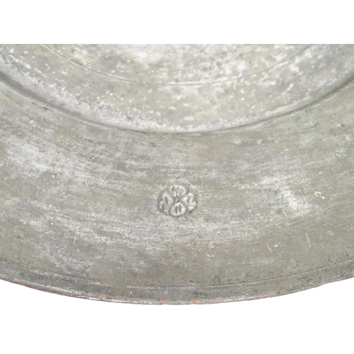 1048 - An Islamic metal charger with incised fish decoration to centre and scrolling motifs to border. Appr... 