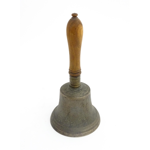 1050 - A 20thC hand bell with turned wooden handle, stamped WH to top to bell. Approx. 10 1/2