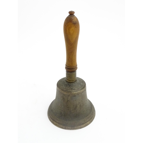 1050 - A 20thC hand bell with turned wooden handle, stamped WH to top to bell. Approx. 10 1/2