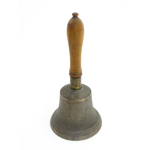 1050 - A 20thC hand bell with turned wooden handle, stamped WH to top to bell. Approx. 10 1/2