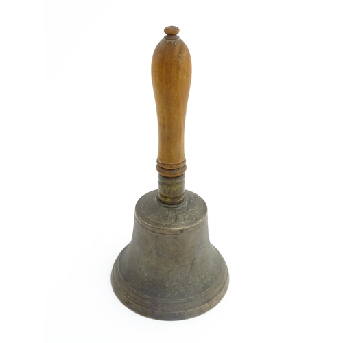 1050 - A 20thC hand bell with turned wooden handle, stamped WH to top to bell. Approx. 10 1/2