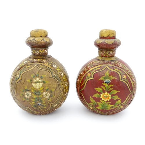 1161 - Two Indian metal vases of moon flask form decorated with flowers and foliage. Approx. 10