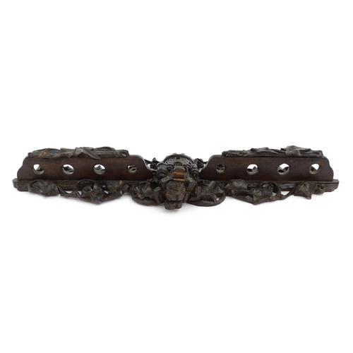 1196 - An early 20thC Black Forest pipe rack with provision for eight pipes, with carved castle and drawbri... 