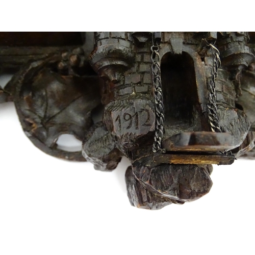 1196 - An early 20thC Black Forest pipe rack with provision for eight pipes, with carved castle and drawbri... 