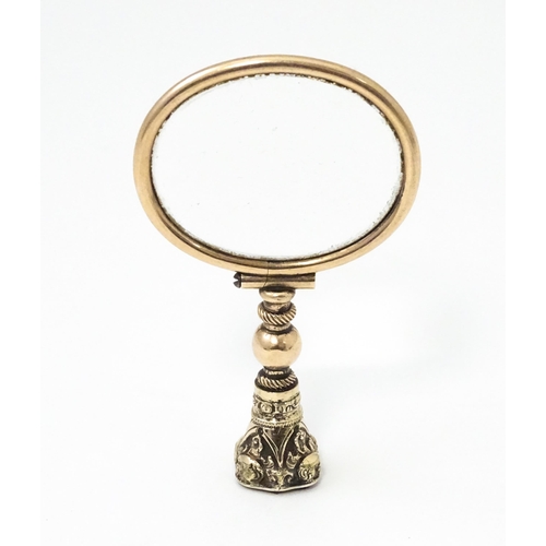 1207 - A 19thC gilt metal quizzing eye glass with carnelian seal to handle. Approx. 2 1/2