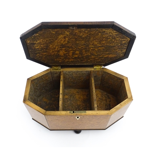 1220 - A 19thC tea caddy of octagonal form with crossbanded rosewood top raised on four feet, opening to re... 