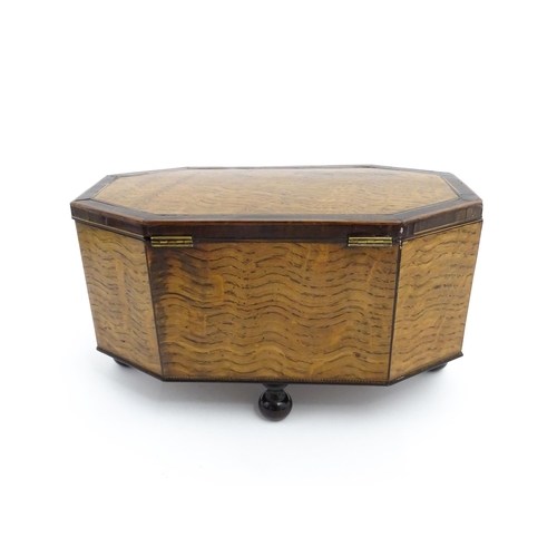 1220 - A 19thC tea caddy of octagonal form with crossbanded rosewood top raised on four feet, opening to re... 