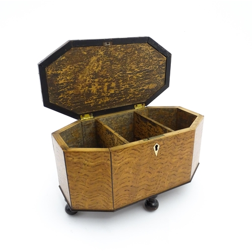 1220 - A 19thC tea caddy of octagonal form with crossbanded rosewood top raised on four feet, opening to re... 