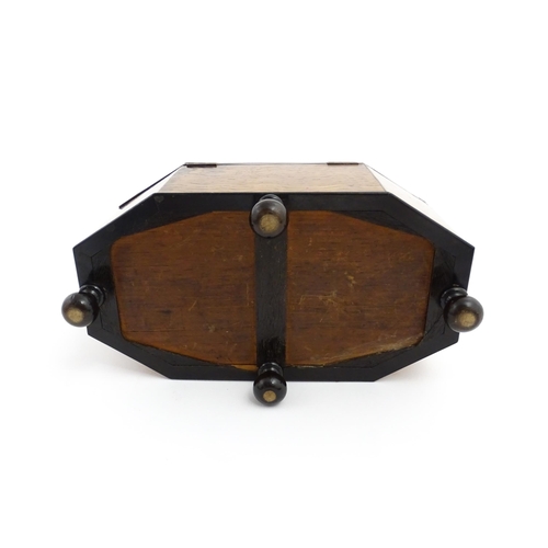 1220 - A 19thC tea caddy of octagonal form with crossbanded rosewood top raised on four feet, opening to re... 