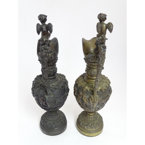 1230 - A pair of early 20thC cast ornamental ewers decorated in relief with fruiting vine and banded putti ... 