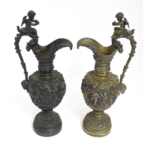 1230 - A pair of early 20thC cast ornamental ewers decorated in relief with fruiting vine and banded putti ... 